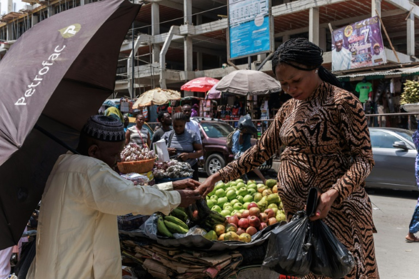 Une femme achète des fruits sur un marché à Lagos, le 8 mars 2024 au Nigeria © Benson Ibeabuchi