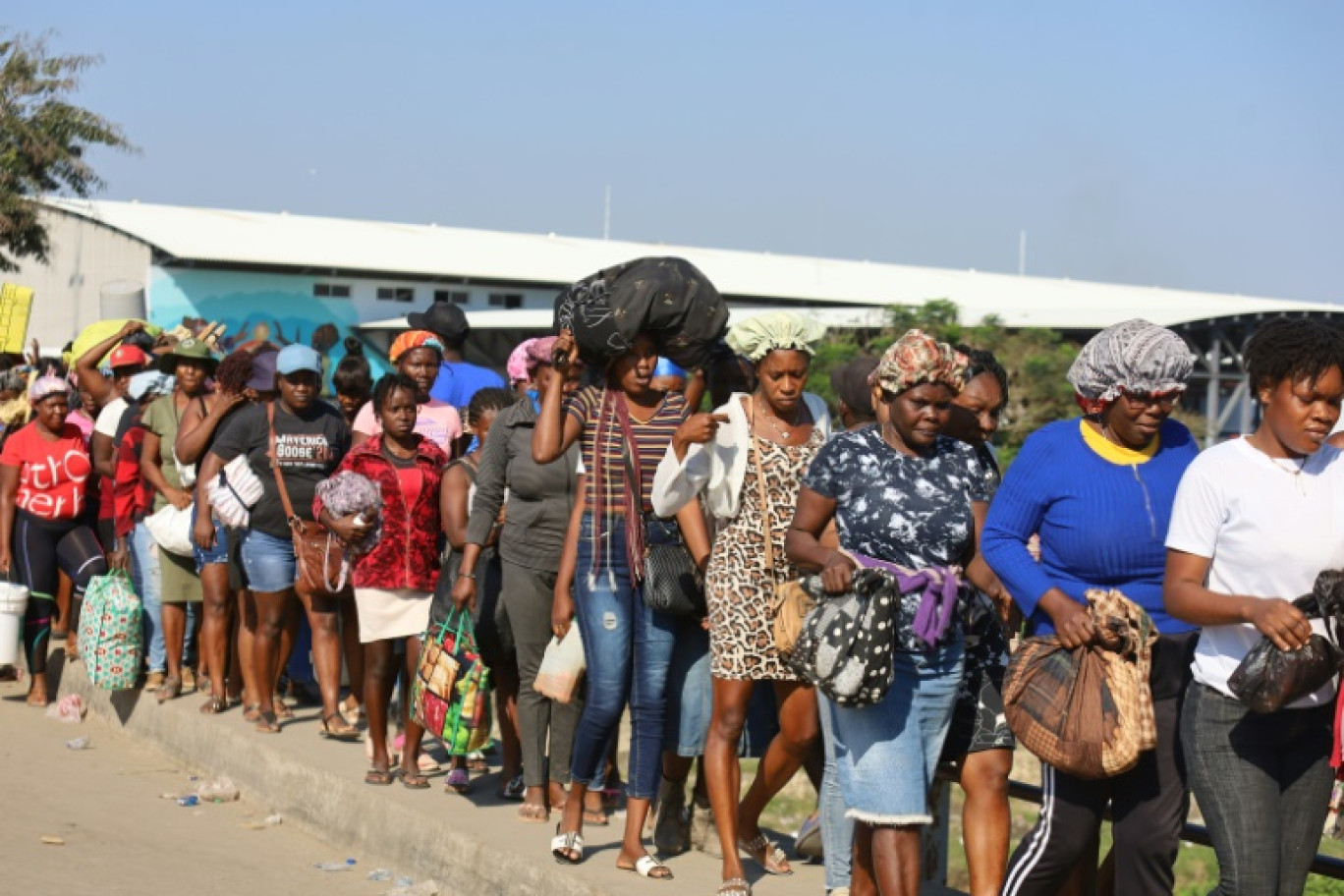 Des Haïtiens franchissent la frontière avec la République dominicaine le 8 mars 2024 pour participer au marché binational © Erickson POLANCO