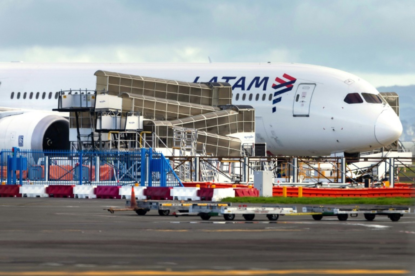 Des voyageurs au comptoir de la Latam Airlines à l'aéroport d'Auckland, au lendemain d'un "incident" technique sur un Boeing 787 de la compagnie, le 12 mars 2024 en Nouvelle-Zélande © BRETT PHIBBS