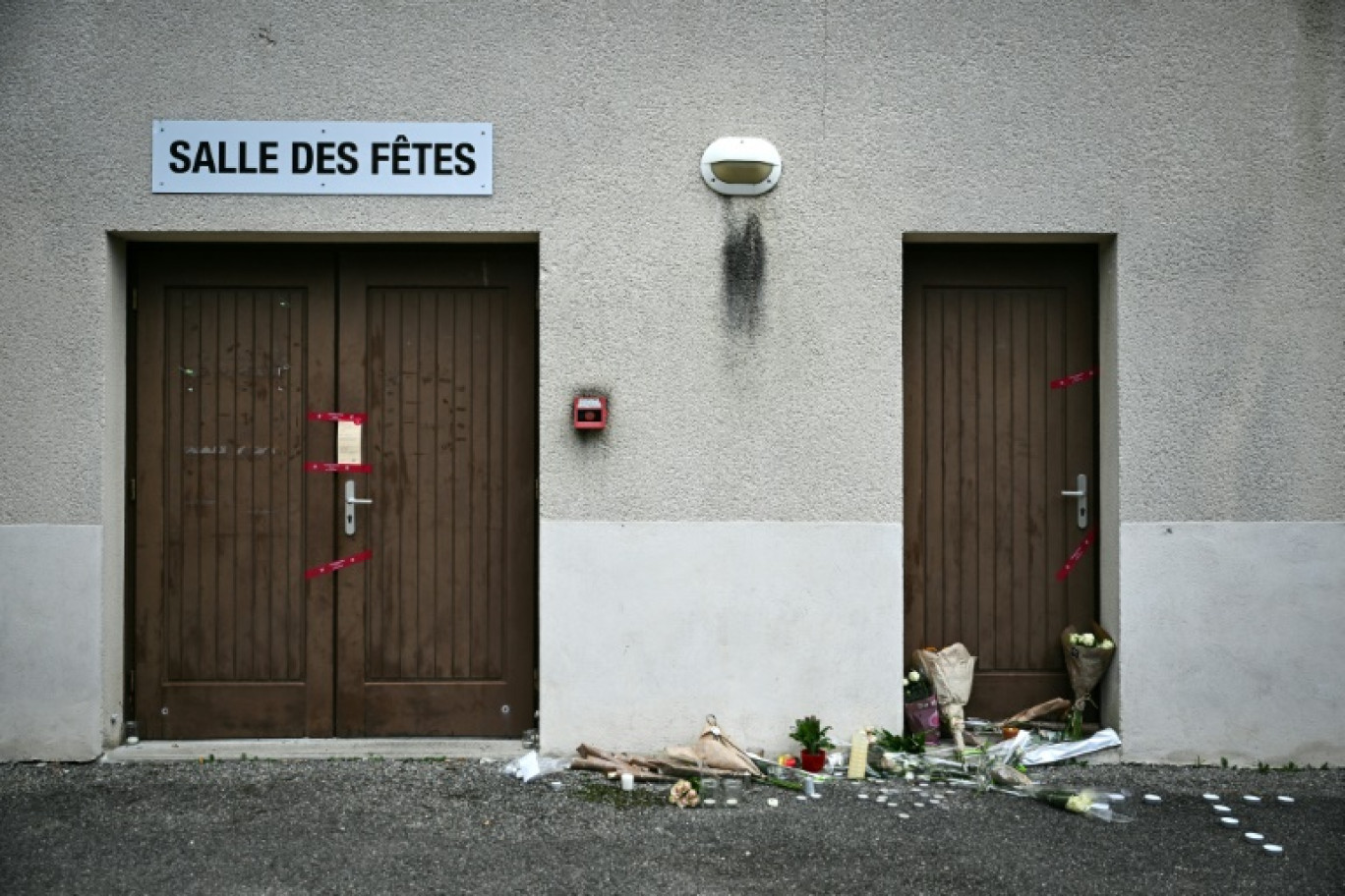 Des fleurs déposées devant la salle des fêtes de Crépol, le 22 novembre 2023 dans la Drôme, où le jeune Thomas est décédé le 19 novembre 2023 après avoir été blessé d'un coup de couteau au cours d'un bal © OLIVIER CHASSIGNOLE