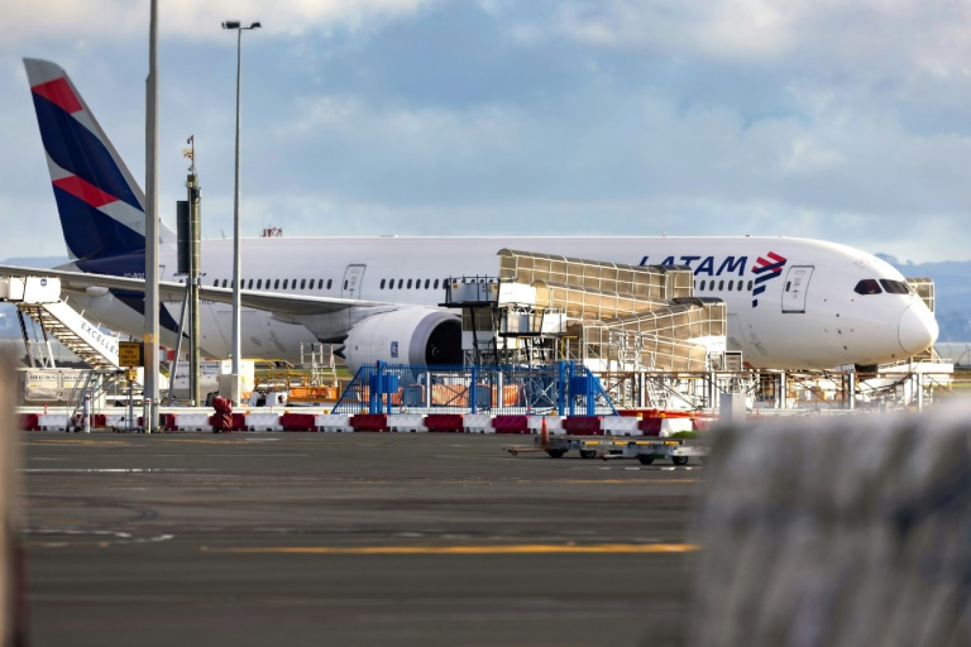 Un Boeing 787 Dreamliner de la compagnie LATAM Airlines, qui a soudainement perdu de l'altitude en plein vol la veille, stationné sur le tarmac de l'aéroport international d'Auckland, le 12 mars 2024 en Nouvelle-Zélande © BRETT PHIBBS