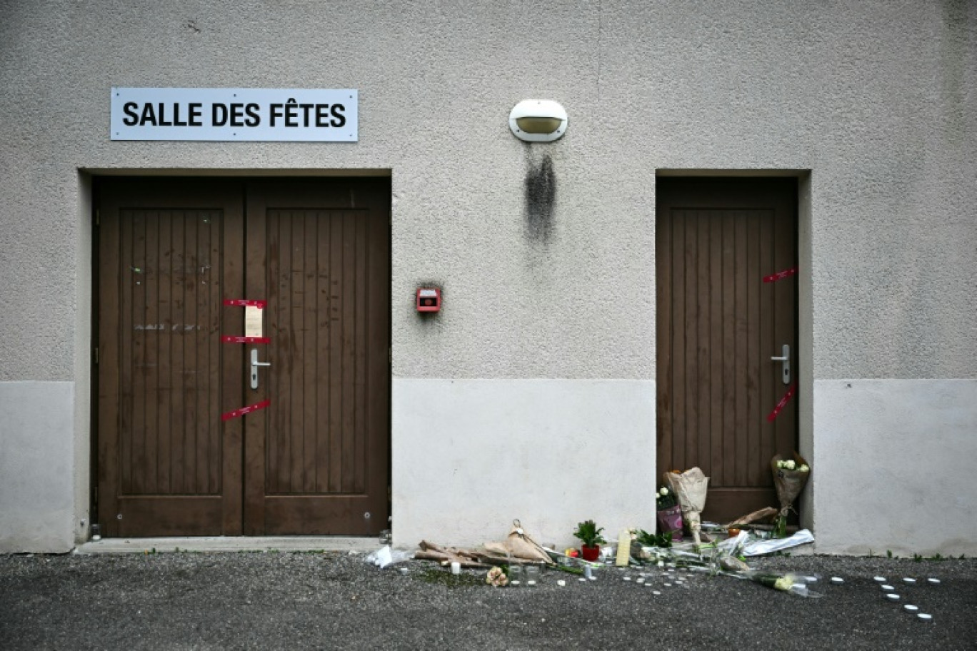 Des fleurs déposées devant la salle des fêtes de Crépol, le 22 novembre 2023 dans la Drôme, où Thomas est décédé le 19 novembre 2023 après avoir été blessé d'un coup de couteau © OLIVIER CHASSIGNOLE