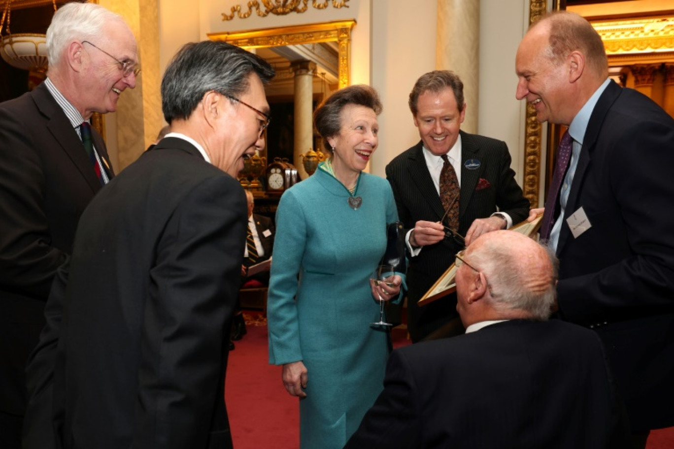 Britain's Princess Anne, Princess Royal (C), and South Korea's Ambassador to the United Kingdom, Yoon Yeocheol (2L) laugh as they talk with War veterans during a reception for Korean war veterans, to mark the 70th anniversary of the Korean War, which they hosted on behalf of Britain's King Charles III at Buckingham Palace in central London on March 19, 2024. © Tristan Fewings