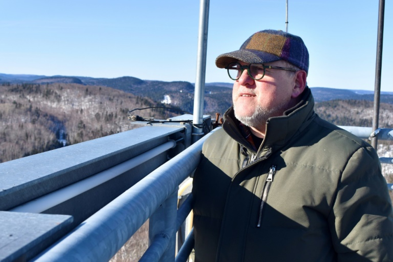 Yvan Lafontaine contemple son vaste terrain, visé par un claim minier, du haut d'une tour d'observation à St-Mathieu-du-Parc, Québec, Canada le 20 février 2024 © Genevieve Normand