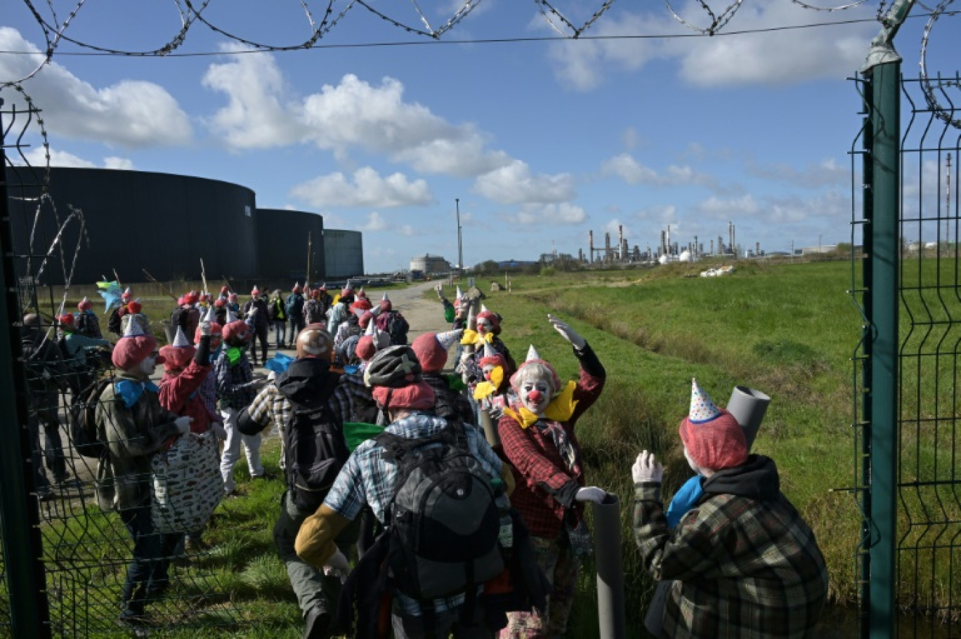 Des militants d'Extinction Rebellion (ER) déguisés en clowns sur le site de la raffinerie de TotalEnergies à Donges (Loire-Atlantique) le 23 mars 2024 © DAMIEN MEYER