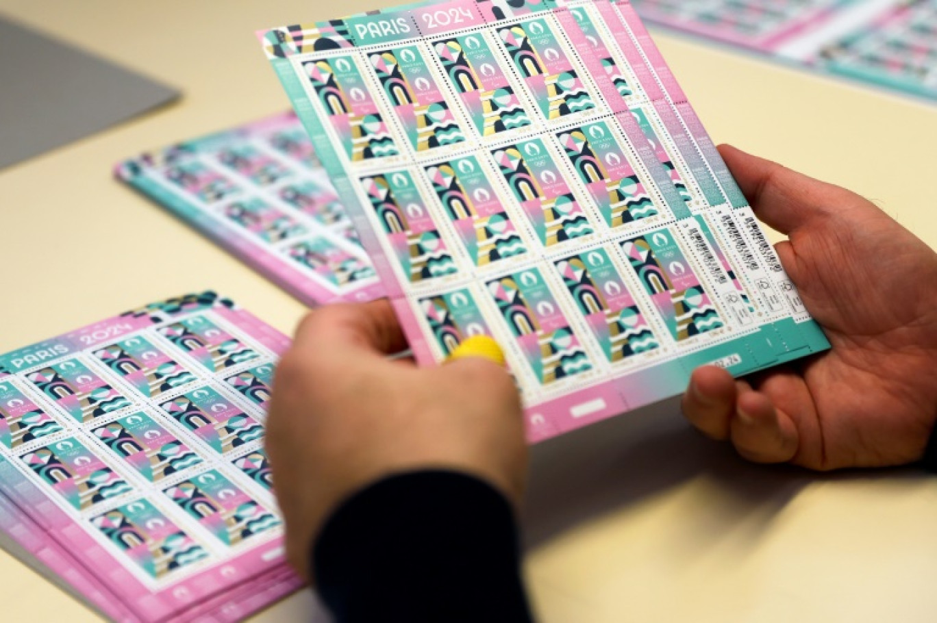 Un employé de l'imprimerie de Boulazac (Dordogne) vérifie la qualité de timbres spécialement édités par La Poste pour les Jeux olympiques de Paris-2024, le 7 mars 2024 © ROMAIN PERROCHEAU