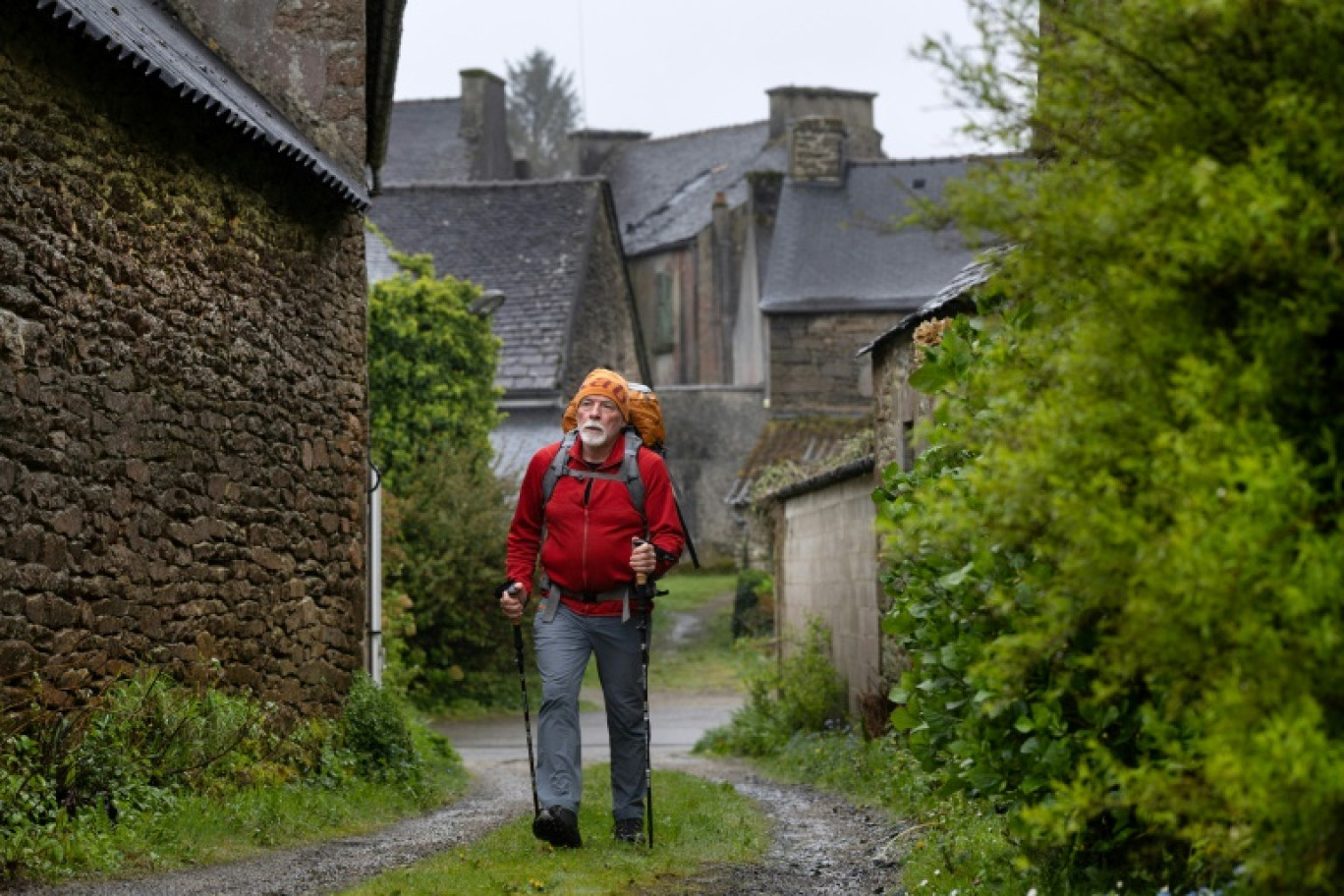 Le randonneur français Jean-Paul Duault marche sur un sentier à La Feuillée, dans l'ouest de la France, le 10 avril 2024 © Fred TANNEAU