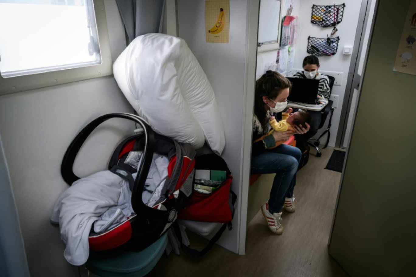 Une sage-femme rencontre une jeune mère et son nouveau-né lors d'une consultation médicale dans le véhicule de l'unité médicale mobile à Condat, dans le Cantal, le 28 mars 2024 © JEAN-PHILIPPE KSIAZEK