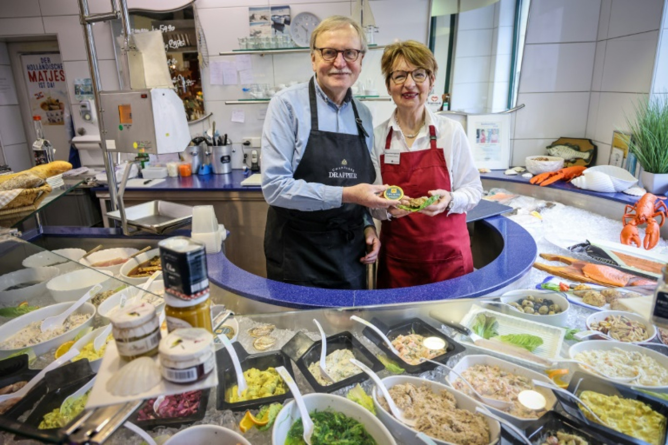 Jürgen Scharringhausen et son épouse Simone dans leur épicerie fine à Brême, dans le nord de l'Allemagne, le 15 mars 2024 © FOCKE STRANGMANN