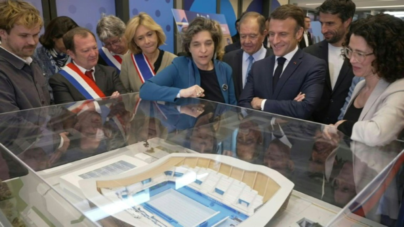 Le président Emmanuel Macron parle avec des enfants lors de l'inauguration du centre aquatique de Saint-Denis, le 4 avril 2024 en Seine-Saint-Denis © Gonzalo Fuentes