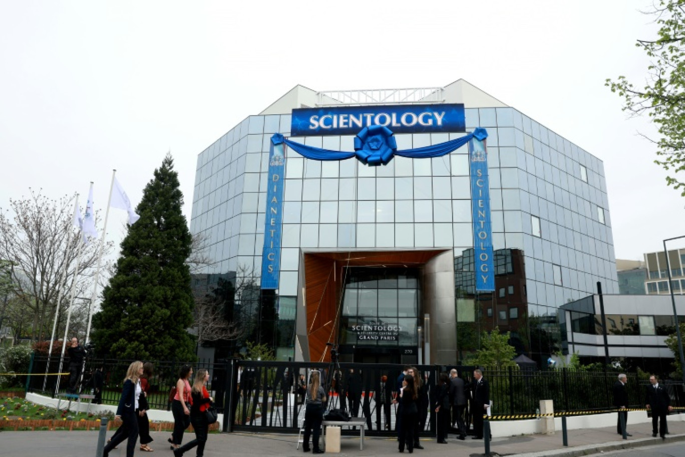 Des personnes invitées à l'inauguration du nouveau centre de formation de l'Eglise de scientologie arrivent devant le bâtiment le 6 avril 2024 à Saint-Denis, près de Paris © Emmanuel Dunand