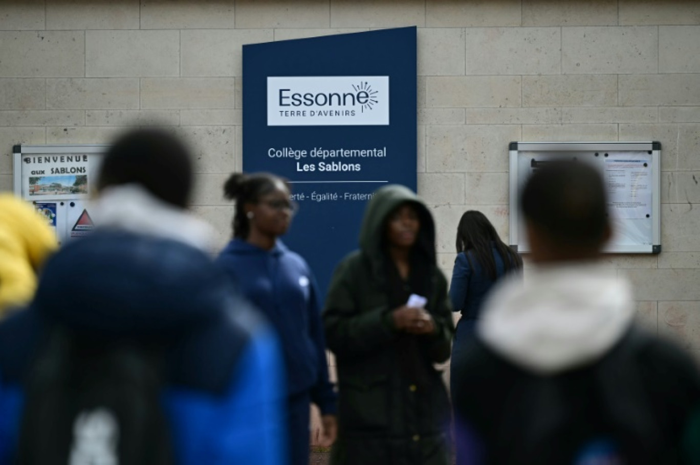 Des élèves, le 5 avril 2024, devant l'entrée du collège Les Sablons à Viry-Châtillon, en Essonne, où était scolarisé un adolescent passé à tabac qui a succombé à ses blessures © Miguel MEDINA