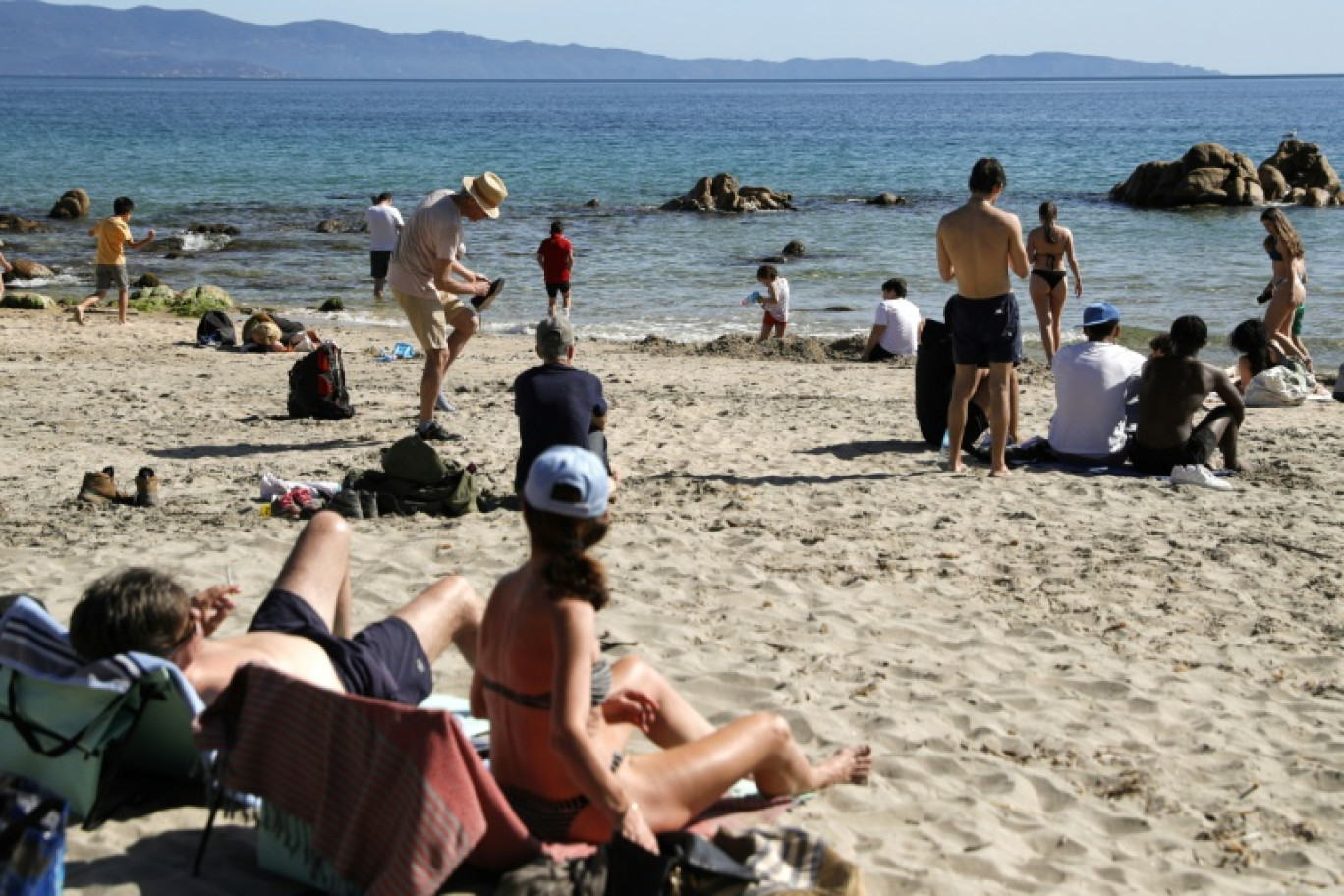 Les gens profitent de la plage avec des températures anormalement élevées pour la saison sur la plage de Terre Sacrée à Ajaccio,  en Corse, le 6 avril 2024 © Pascal POCHARD-CASABIANCA