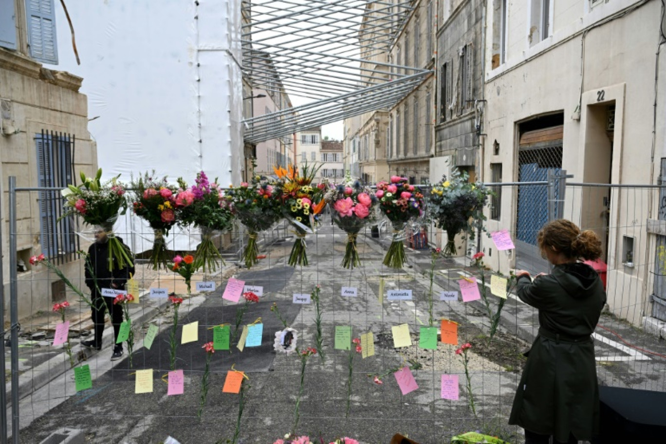 Une femme laisse un message lors d'une cérémonie commémorative marquant le premier anniversaire de l'effondrement d'un immeuble dans la rue Tivoli à Marseille, le 9 avril 2024 © Nicolas TUCAT