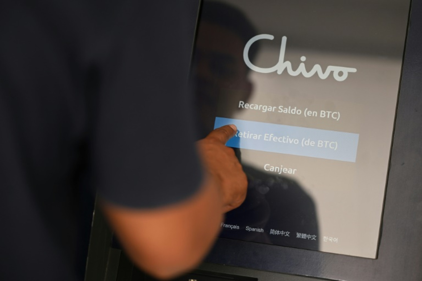 Un homme utilise le portefeuille électronique du gouvernement salvadorien, connu sous le nom de "Chivo", pour retirer de l'argent émis par des membres de sa famille à l'étranger, le 8 avril 2024 à San Salvado © Marvin RECINOS