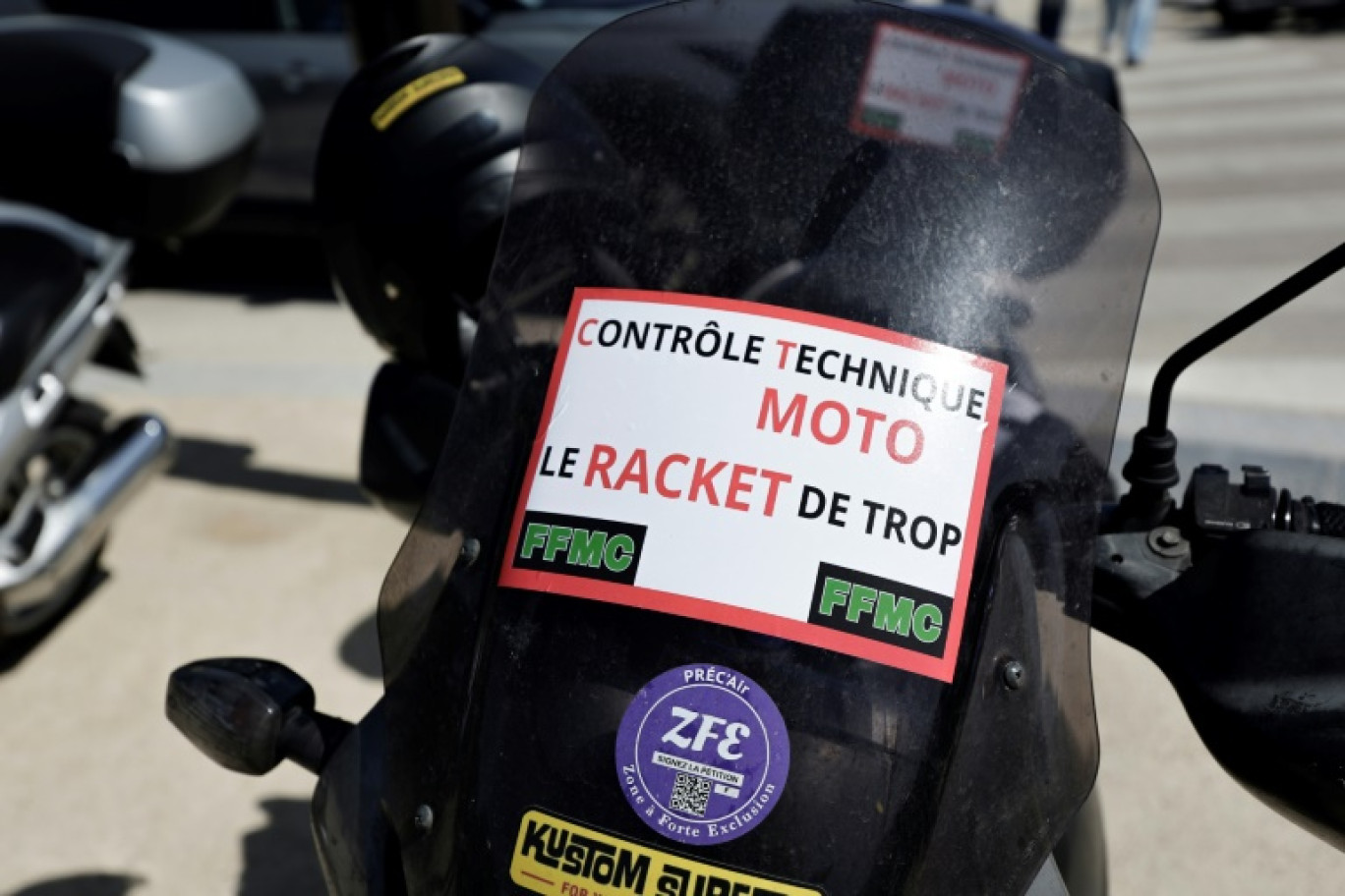 "Contrôle technique moto: le racket de trop", indique l'affiche déposée sur la moto d'un manifestant le 13 avril 2024 à Paris © STEPHANE DE SAKUTIN