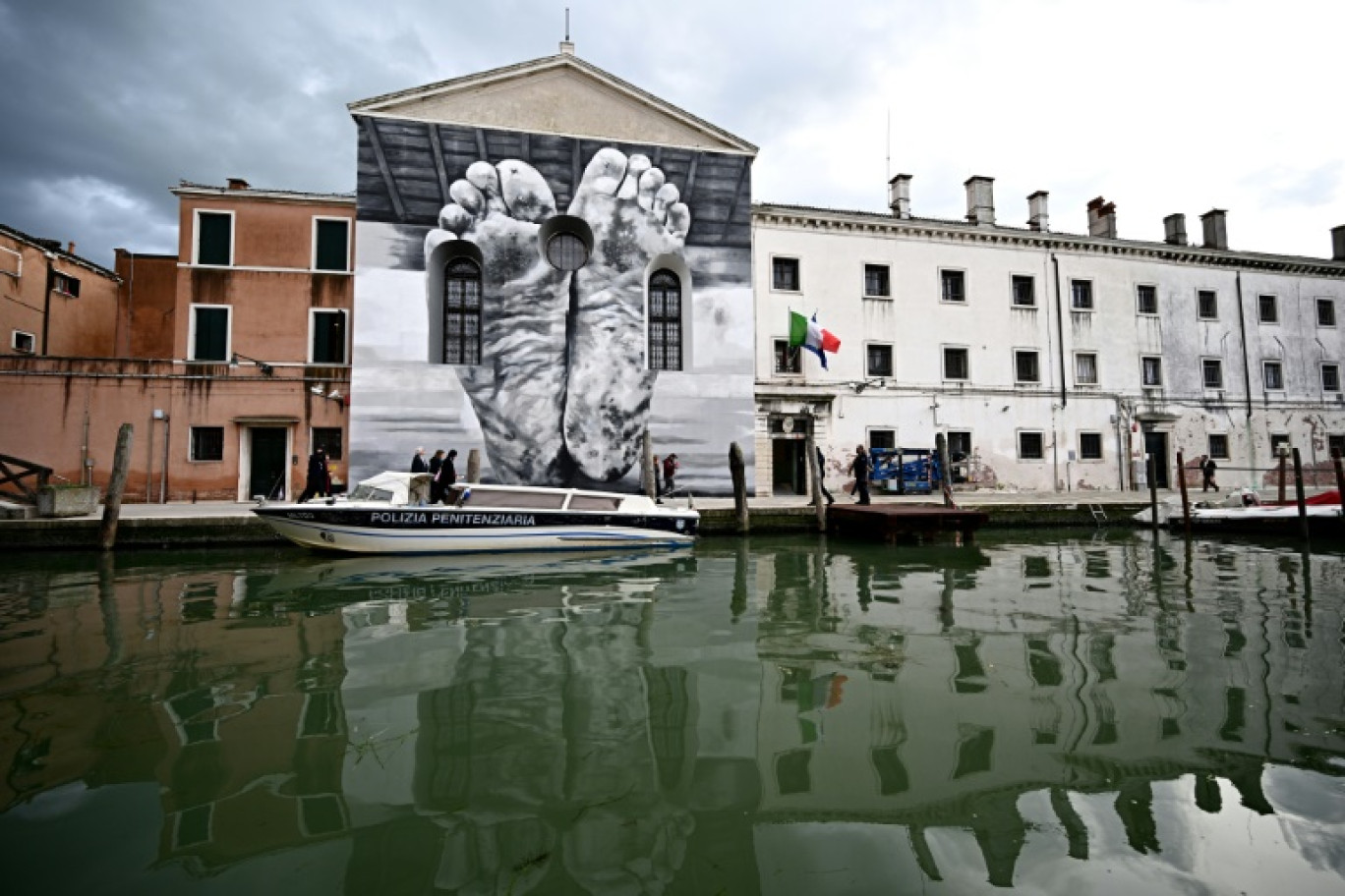 Une fresque murale de l'artiste Maurizio Cattelan sur la façade de la prison pour femmes de la Giudecca, abritant le pavillon du Vatican, lors de la pré-ouverture de la 60e exposition d'art de la Biennale de Venise, le 18 avril 2024 © GABRIEL BOUYS