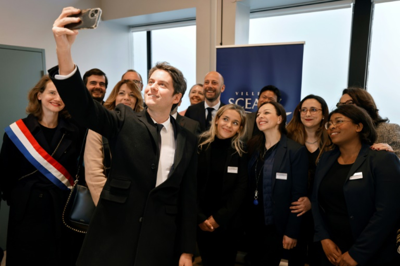 Le Premier ministre Gabriel Attal et le ministre des Services Publics Stanislas Guerini (arrière-plan, c) avec le personnel de "France Services" à Sceaux, le 23 avril 2024 dans les Hauts-de-Seine © Ludovic MARIN