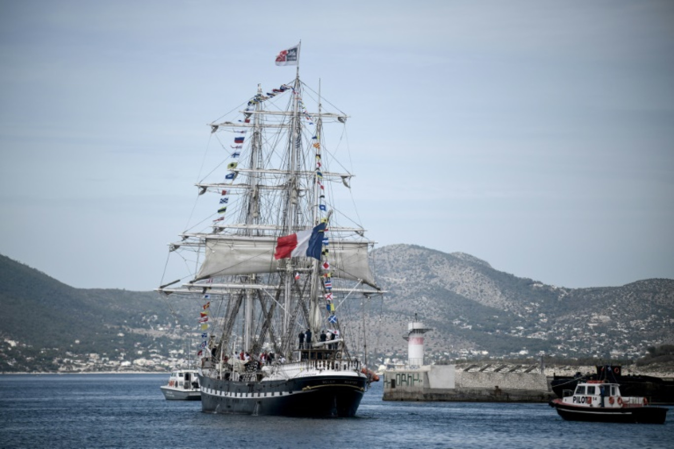 Le Belem, trois-mâts français du XIXe siècle, quitte le port du Pirée, près d'Athènes, avec la flamme olympique à son bord pour entamer son voyage vers la France le 27 avril 2024, un jour après que la Grèce a remis le flambeau des Jeux de 2024 aux organisateurs parisiens © Angelos Tzortzinis