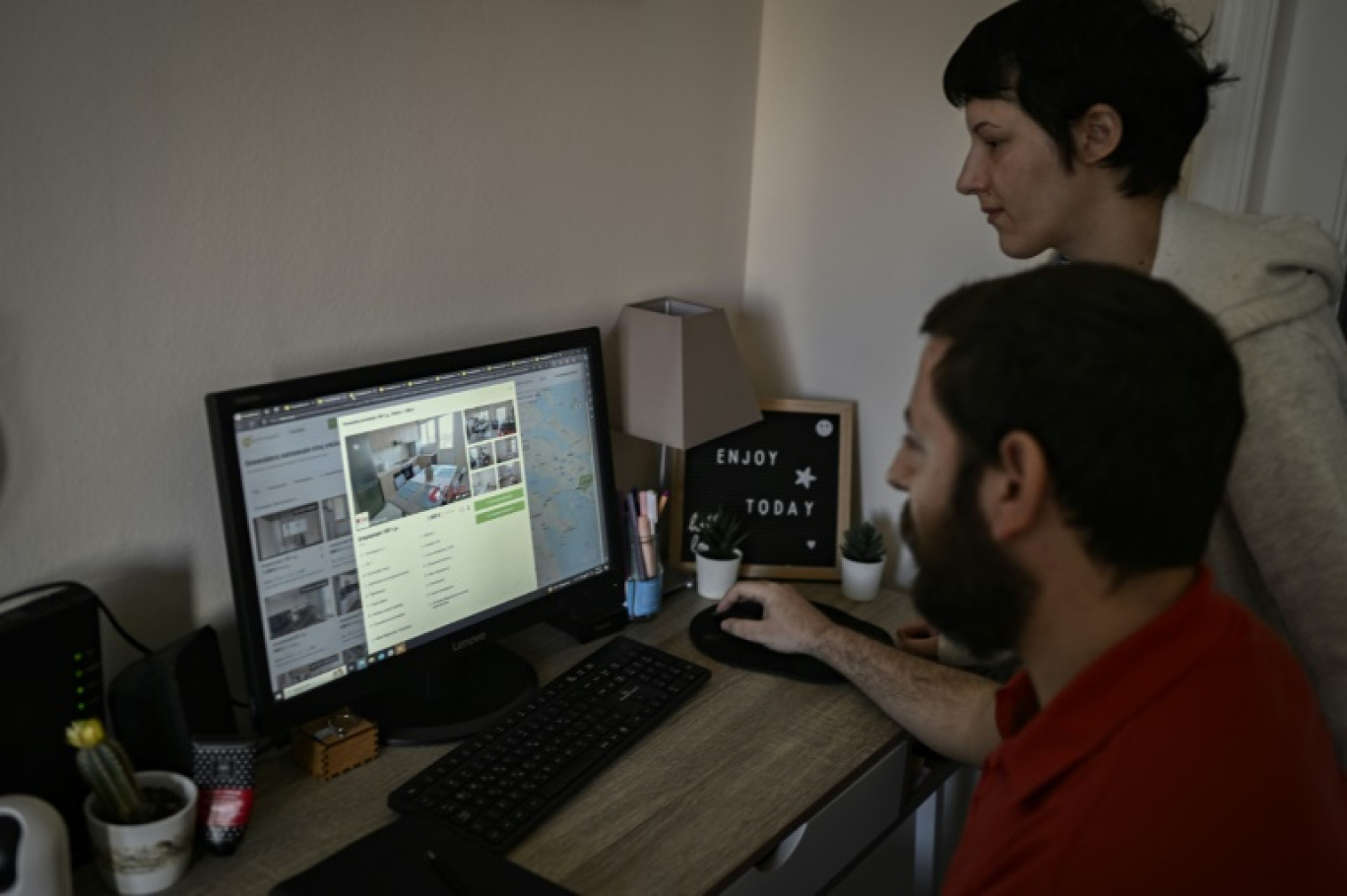 Kyriaki Tsouti (d) et son compagnon Dionyssis Giakoumelos consultent les annonces de location d'appartement sur internet, le 10 avril 2024 à Athènes © Aris MESSINIS