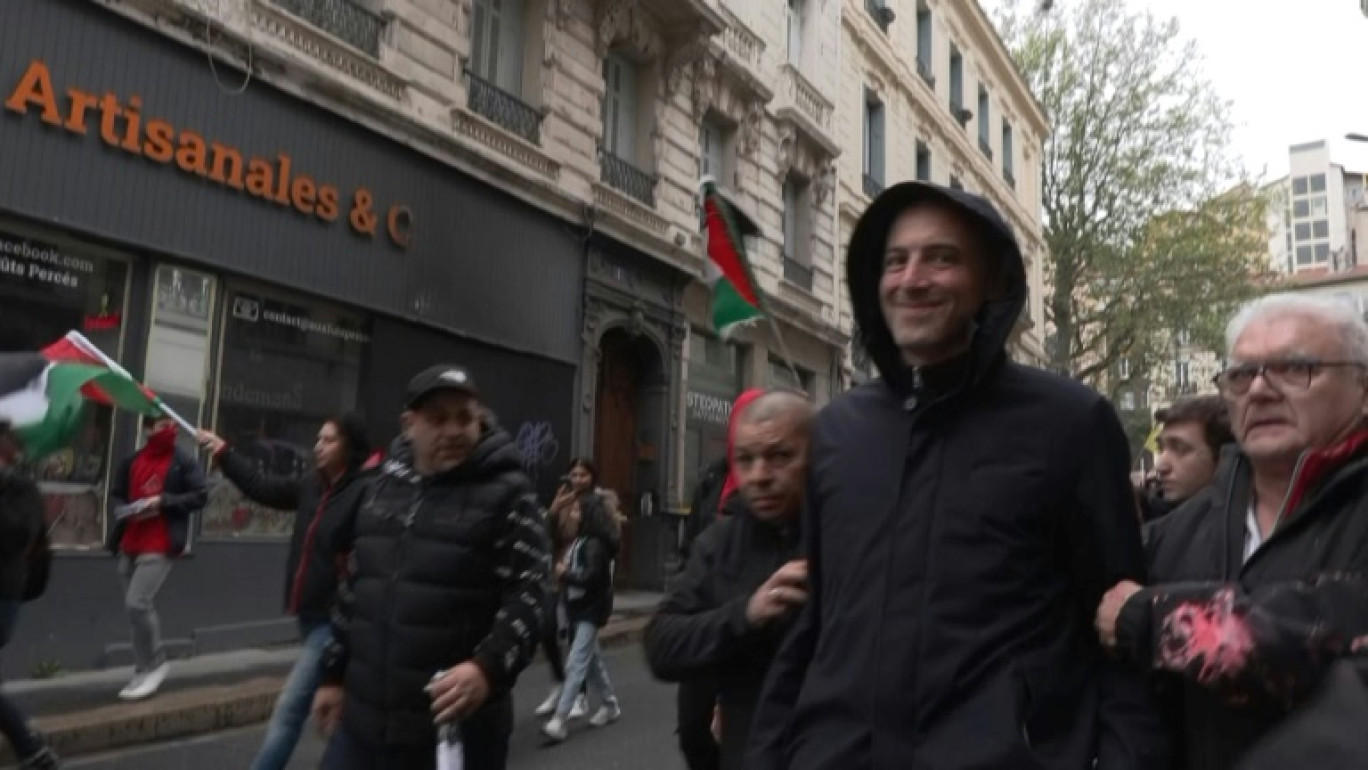 Image tirée d'une vidéo de l'AFPTV, le 1er mai 2024, de Raphael Glucksmann empêché de rejoindre le cortège à Saint-Etienne après des jets de peinture © Marine LESPRIT