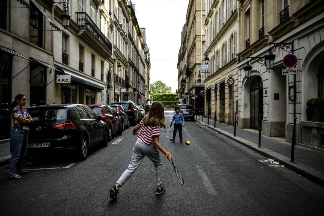 Des enfants jouent au tennis dans une rue déserte de Paris, pendant le confinement instauré lors de l'épidémie de Covid-19, le 21 avril 2020 © Christophe ARCHAMBAULT