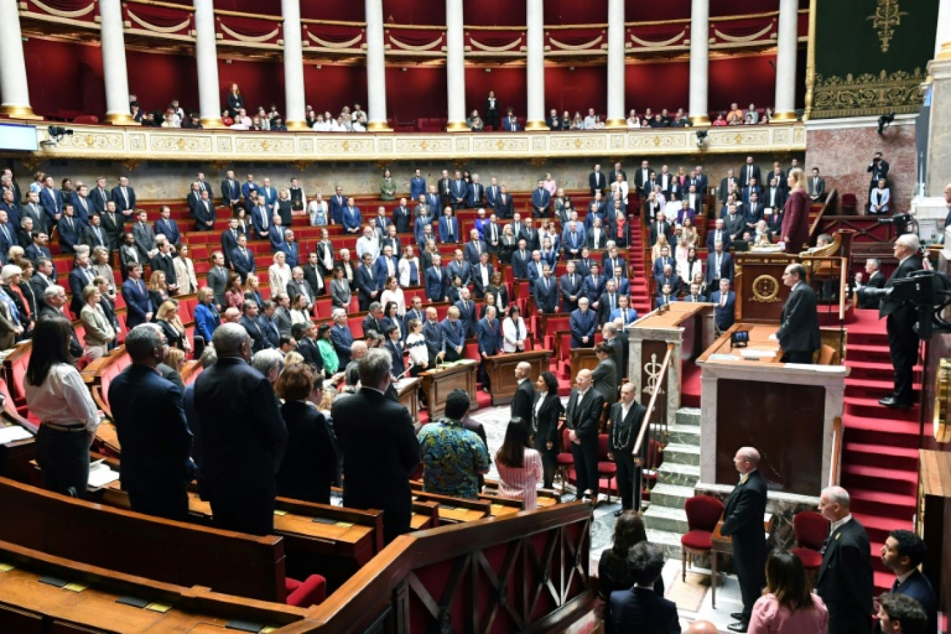 La présidente de l'Assemblée nationale Yaël Braun-Pivet (d) et les députés observent une minute de silence, le 14 mai 2024 à Paris, en hommage aux agents de la pénitentiaire tués lors d'une attaque à la voiture bélier contre leur fourgon au péage d'Incarville, dans l'Eure © Mehdi FEDOUACH