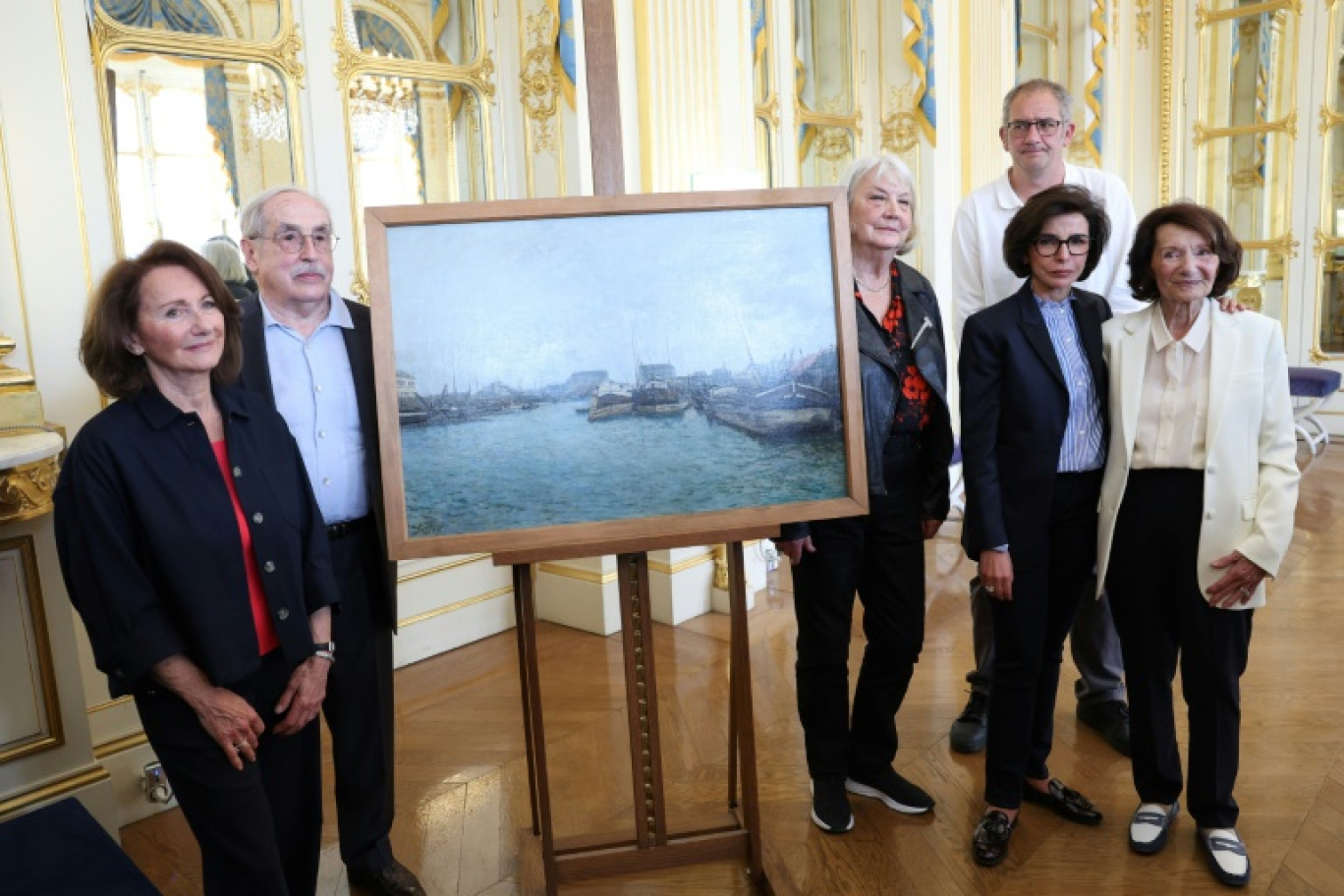 La ministre de la Culture Rachida Dati pose avec des ayants droit d'un galeriste juif, Grégoire Schusterman, spolié pendant l'Occupation, devant un tableau de Sisley, intitulé "Les Péniches" le 16 mai 2024 à Paris © ALAIN JOCARD