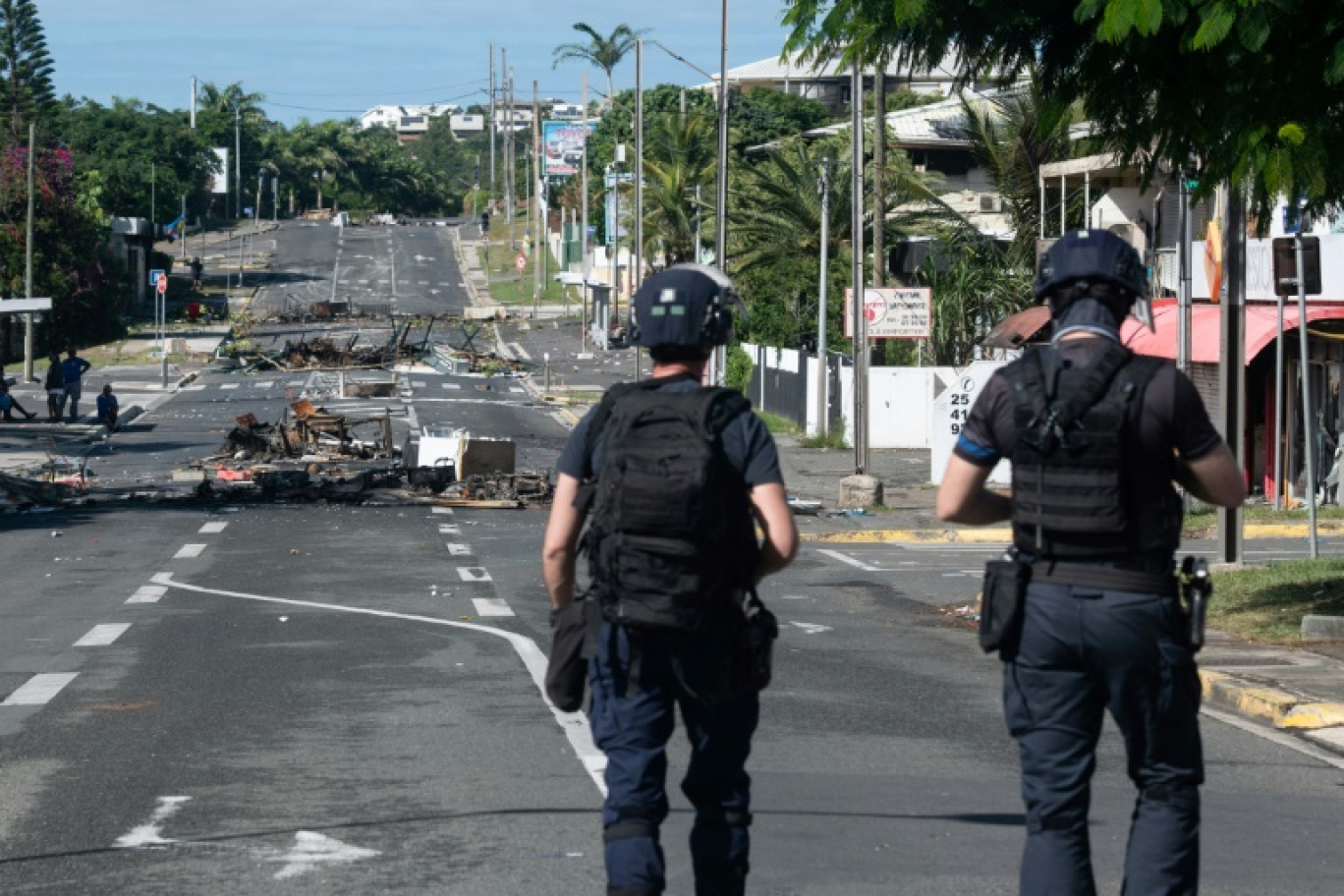 Des véhicules incendiés gisent sur une route menant à Nouméa, dans le territoire français de Nouvelle-Calédonie, le 20 mai 2024 © Theo Rouby