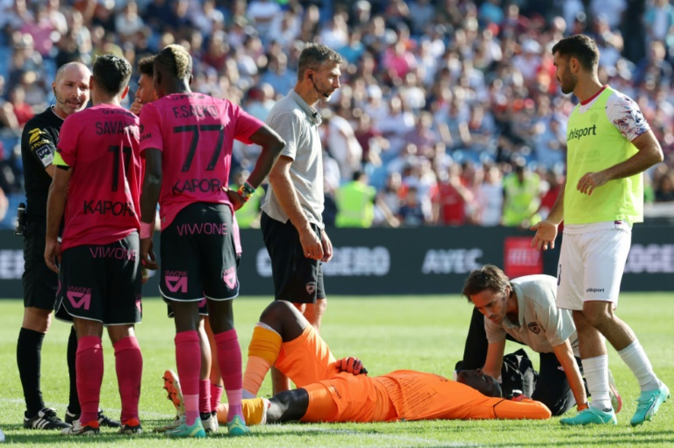 Le gardien de Clermont Mory Diaw (C) est pris en charge après l'explosion d'un pétard à côté de lui, lors du match de Ligue 1 à Montpellier le 8 octobre 2023 © Pascal GUYOT