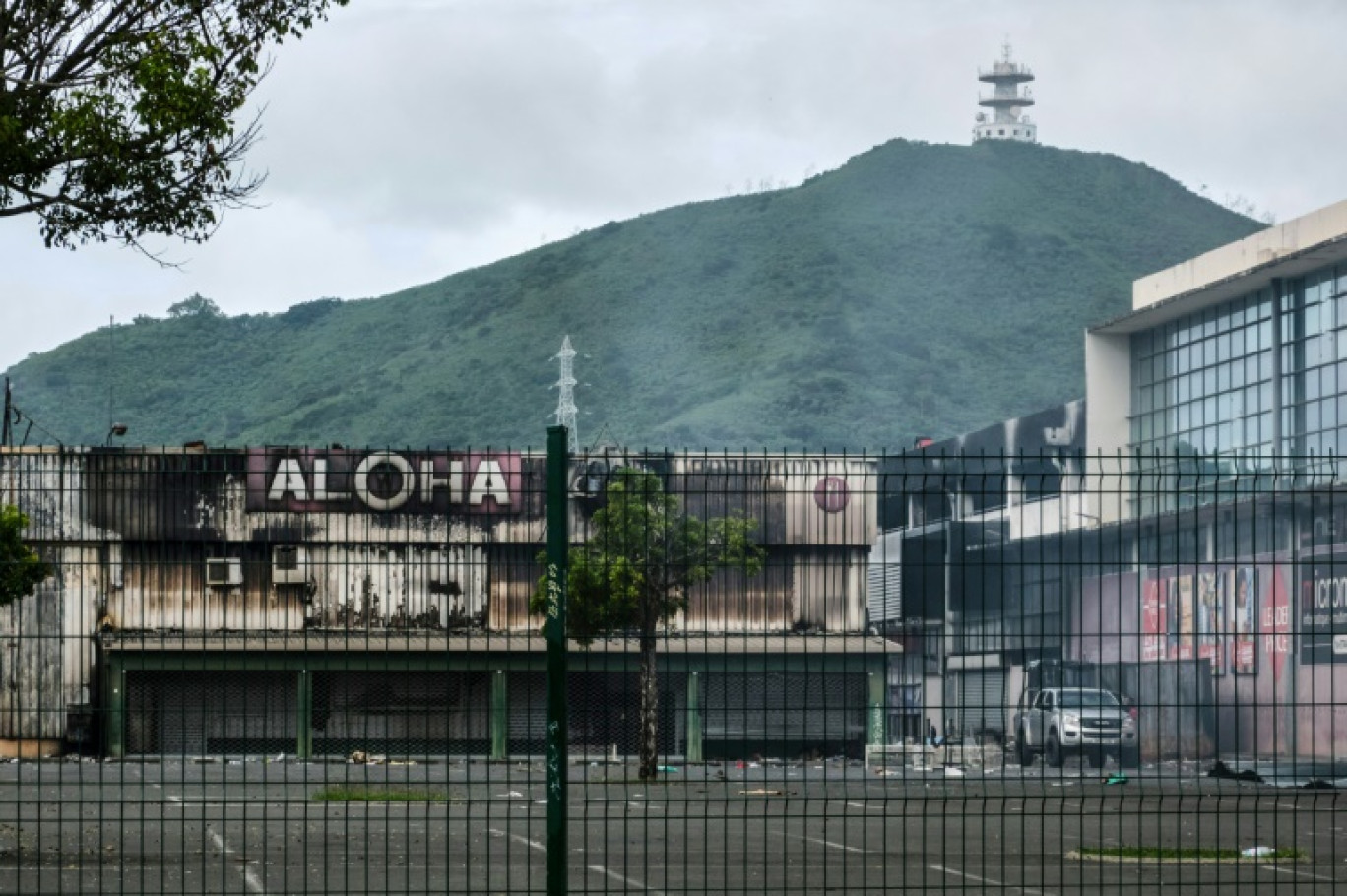 Des commerces en partie incendiés dans le quartier Ducos de Noumea, en Nouvelle-Calédonie, le 21 mai 2024 © Theo Rouby