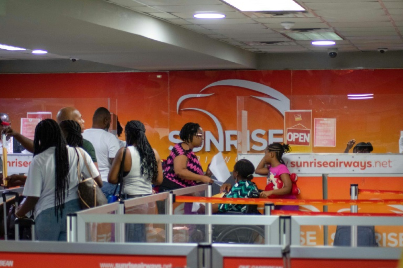 Des voyageurs font la queue au comptoir de la compagnie aérienne Sunrise Airways à l'aéroport Toussaint Louverture de Port-au-Prince, le 20 mai 2024 en Haïti © Clarens SIFFROY