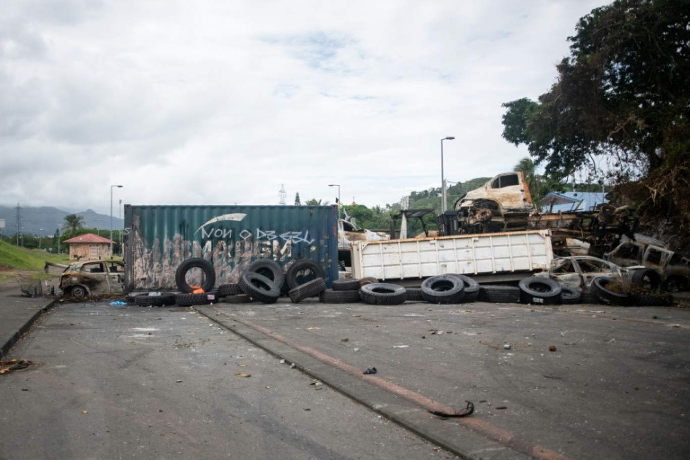 Des voitures brûlées et des pneus sur un barrage à l'entrée du quartier de Montravel à Nouméa, le 21 mai 2024 © Delphine Mayeur