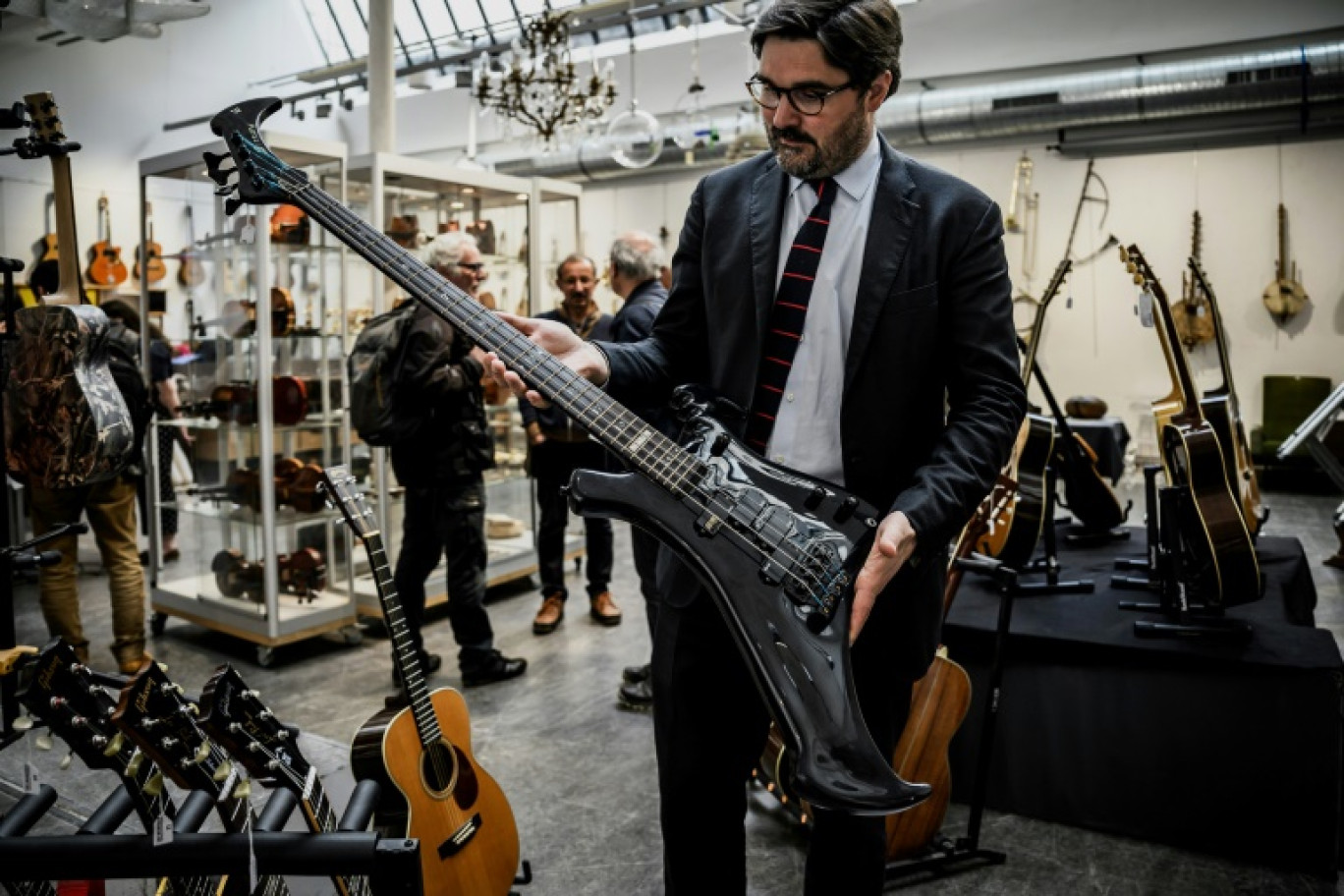 Le commissaire-priseur Etienne de Baecque montre la guitare basse Warwick Buzzard à 4 cordes conçue par John Entwistle, le bassiste du groupe de rock The Who, dans une salle de la maison de vente De Baecke, le 22 mai 2024 à Lyon © JEFF PACHOUD