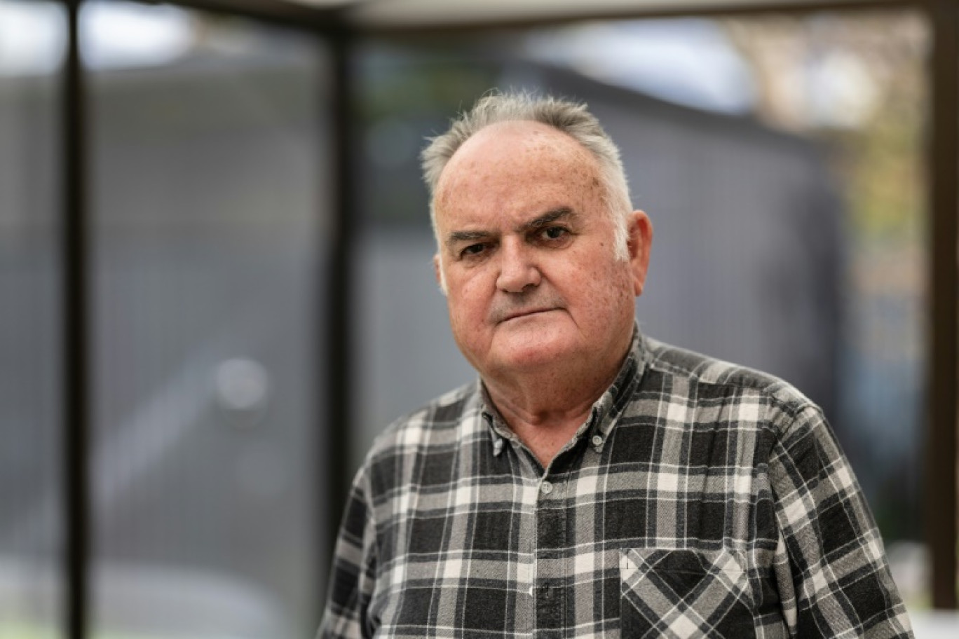 Henri Letty, atteint d'une leucémie et d'un cancer dus aux radiations nucléaires sur son lieu de travail sur le site de l'Ile Longue, pose dans sa maison de Brest, le 3 mai 2024 © FRED TANNEAU