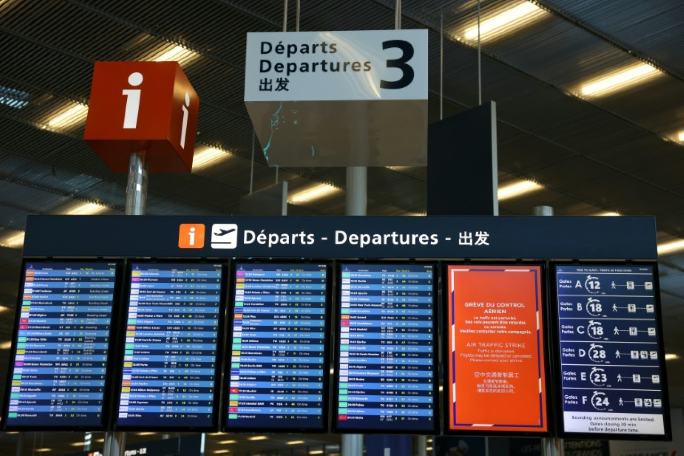 Un panneau annonce un mouvement de grève le 25 avril 2024 à l'aéroport d'Orly à côté du tableau des vols au départ © Thomas SAMSON