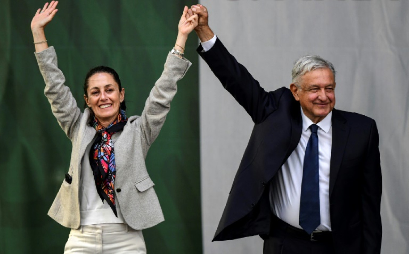 Le président mexicain Andres Manuel Lopez Obrador (D) et la maire de Mexico Claudia Sheinbaum saluent leurs partisans sur la place du Zocalo à Mexico le 1er juillet 2019 © RONALDO SCHEMIDT