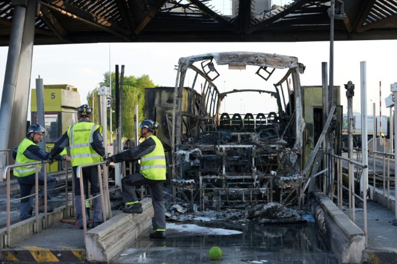 Un autocar calciné après des affrontements entre fans de l'OL et du PSG à un péage d'autoroute, juste avant la finale de la Coupe de France à Lille, le 25 mai 2024 au péage de  Fresnes-lès-Montauban, dans le Pas-de-Calais © Pierre BEAUVILLAIN