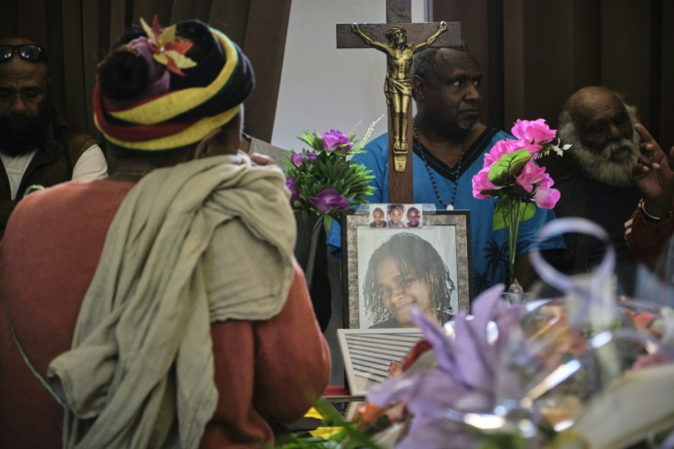 Un homme se recueille devant le portrait de Stéphanie Nasaie Doouka, tuée pendant les émeutes, lors de ses funérailles à Nouméa, le 1er juin 2024 © Theo Rouby