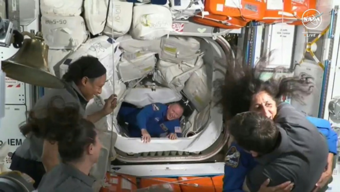 Les astronautes Suni Williams (habillée en bleu à droite) et Butch Wilmore (au centre) entrent dans la Station spatiale internationale après avoir fait le voyage à bord de la capsule Starliner de Boeing, le 6 juin 2024 © Nicholas KAMM