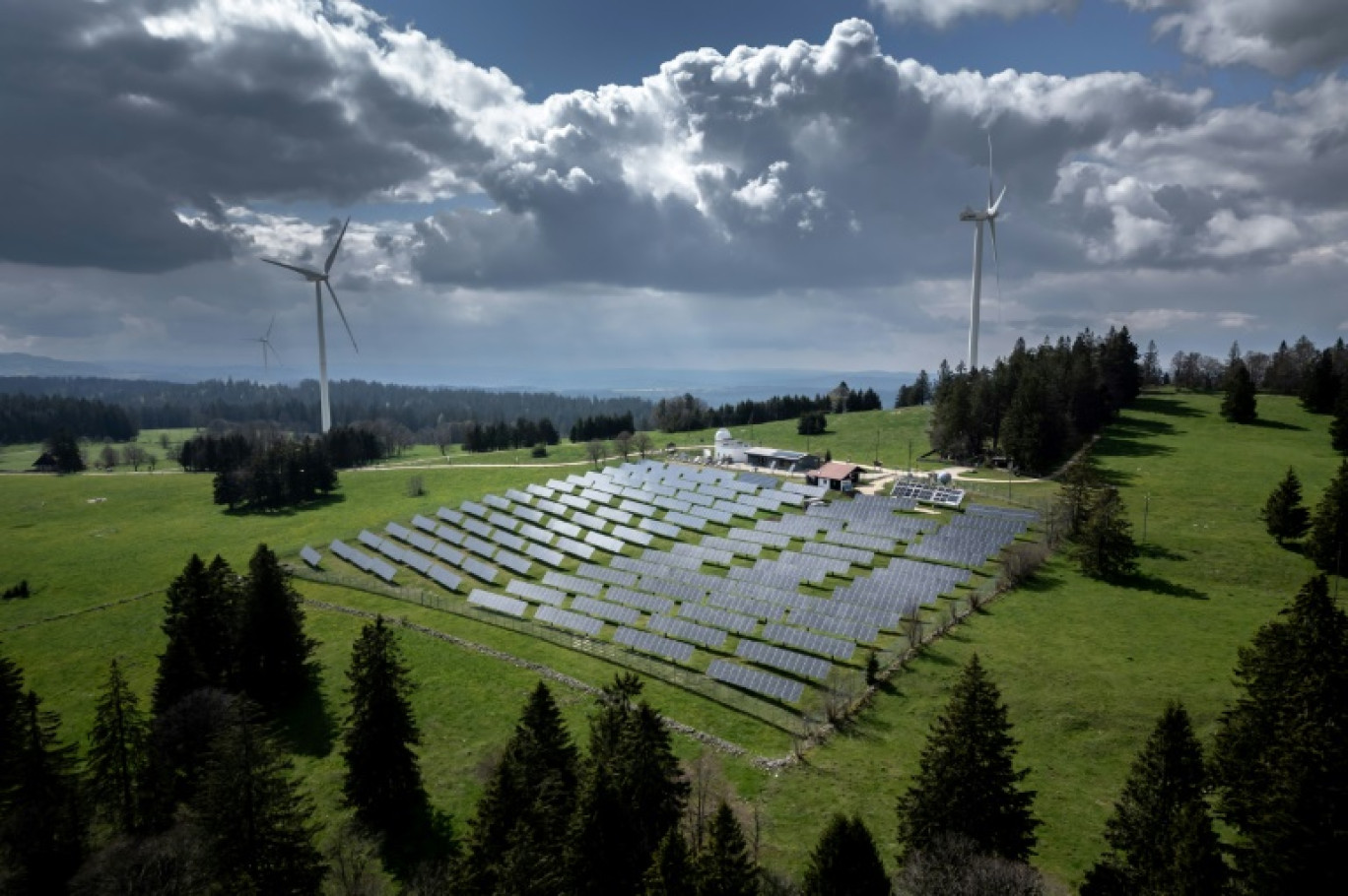 Une ferme de panneaux solaires et des éoliennes sur les hauteurs de Saint-Imier, en Suisse, le 8 mai 2024 © Fabrice COFFRINI