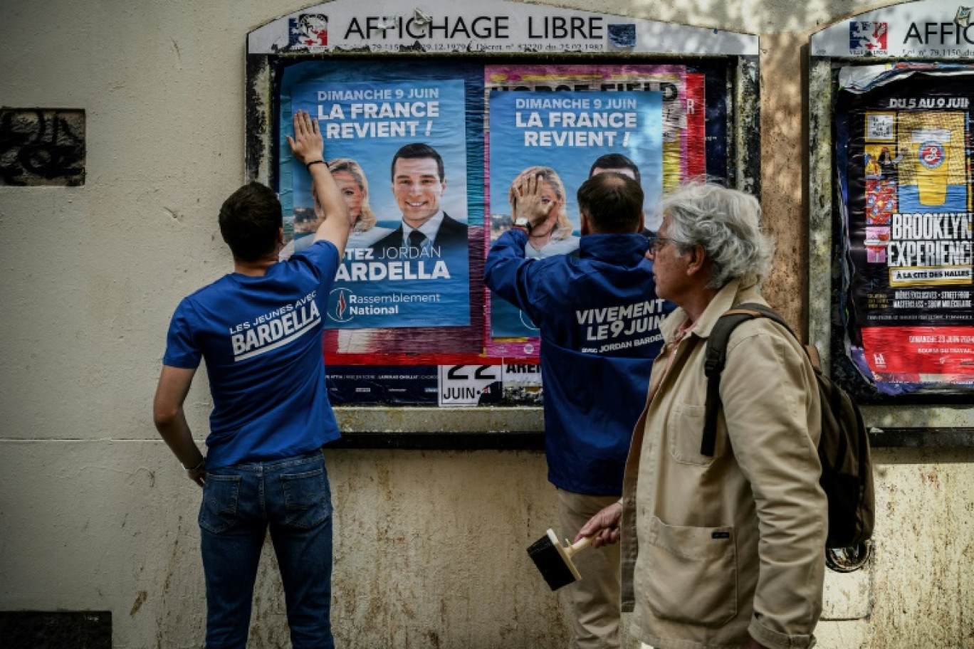 Des bénévoles du RN collent des affiches de campagne de Jordan Bardella, président du parti et tête de liste aux européennes, le 6 mai 2024 à Lyon © JEFF PACHOUD