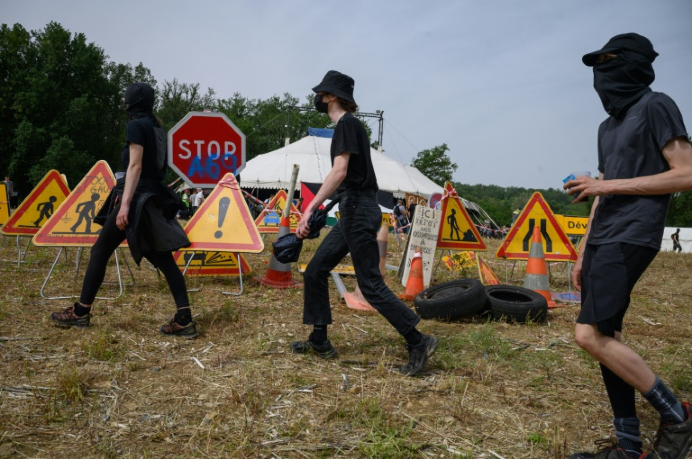 Manifestants devant plusieurs panneaux routiers de travaux, lors de la mobilisation contre l'autoroute A69, près de Puylaurens (Tarn), le 8 juin 2024 © Ed JONES