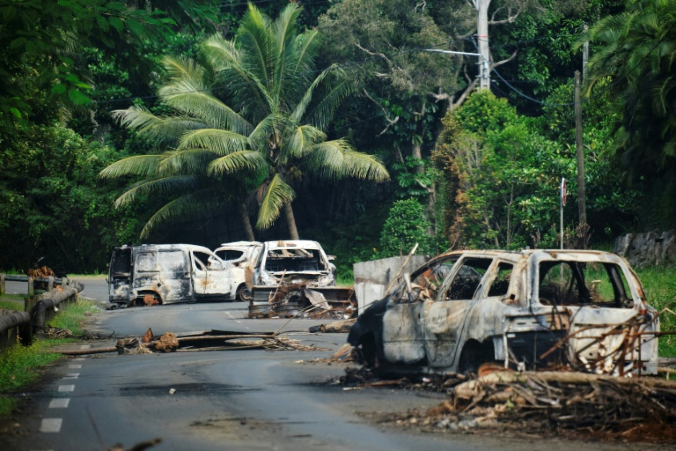 Des véhicules calcinés sur une route traversant la commune de Mont-Dore, en Nouvelle-Calédonie, le 10 juin 2024 © Theo Rouby