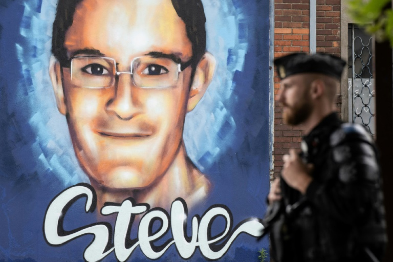 Un policier passe devant une peinture murale en hommage à Steve Maia Canico, décédé lors de la Fête de la musique à Nantes en 2019 © Loic VENANCE