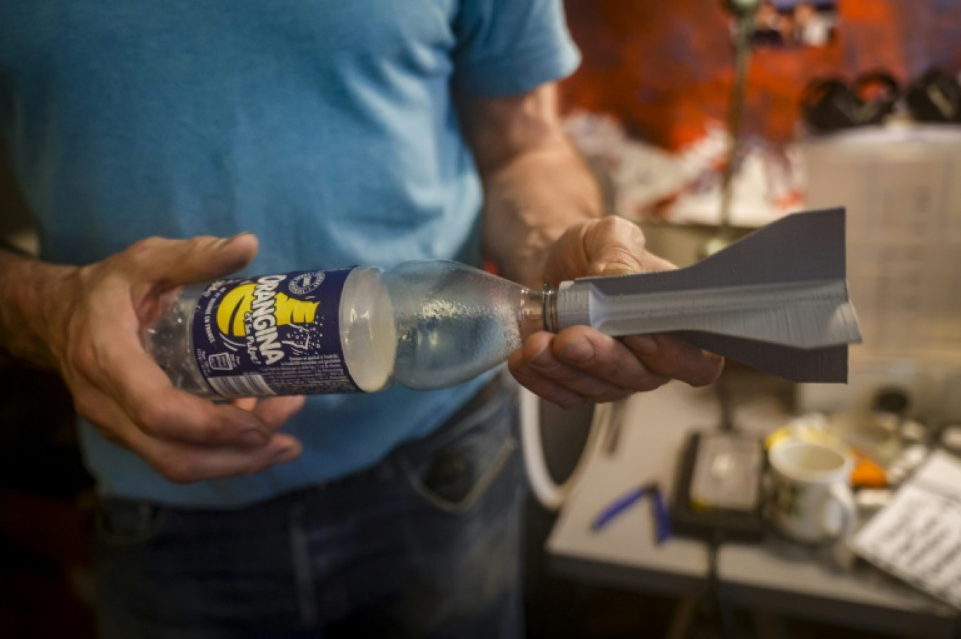 Un bénévole montre le morceau de roquette en plastique qu'il a imprimé chez lui en 3D pour l'envoyer aux forces militaires ukrainiennes, le 1er juin 2024 à Paris © Geoffroy VAN DER HASSELT