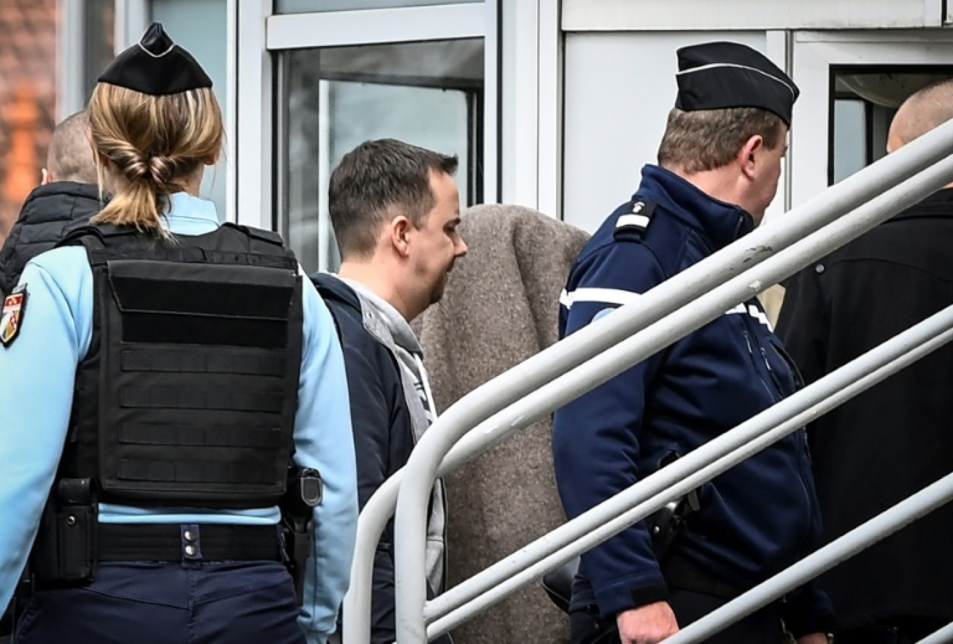 Le meurtrier présumé de la petite Rose, caché sous une couverture, est escorté par des gendarmes, le 26 avril 2023 à Rambervillers, dans les Vosges © Jean-Christophe Verhaegen