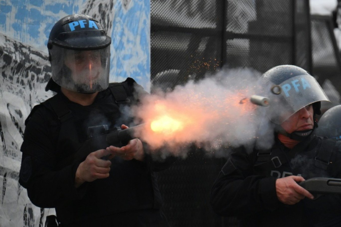 Un policier anti-émeute tire lors de heurts avec des manifestants près du Parlement, à Buenos Aires le 12 juin 2024 © Luis ROBAYO