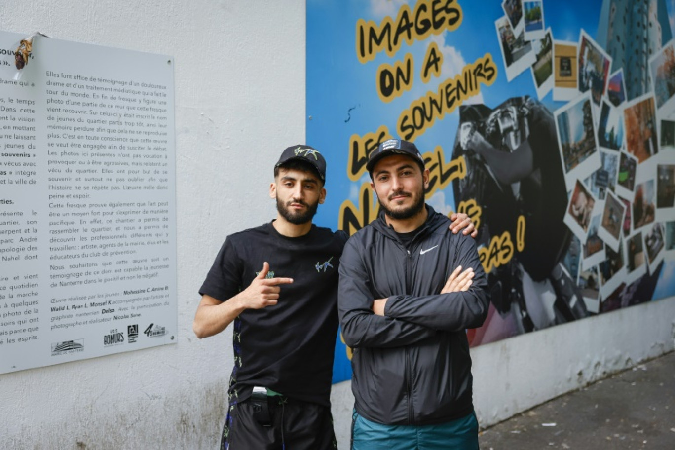 Mohessine (d) et Ryan Lazhar (g) devant la fresque peinte par eux et des amis en hommage à Nahel dans le quartier populaire Pablo-Picasso, le 6 juin 2024 à Nanterre, dans les Hauts-de-Seine © Geoffroy VAN DER HASSELT