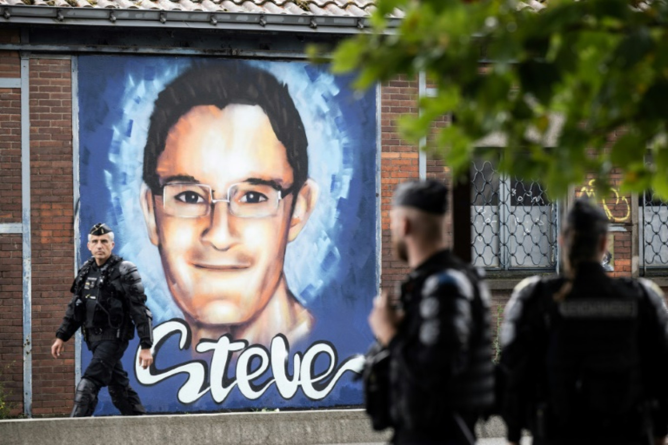 Des policiers devant une fresque murale en hommage à Steve Maia Canico, décédé lors de la Fête de la musique à Nantes en 2019, à l'occasion du troisième anniversaire de sa mort, le 21 juin 2022 à Nantes © Loic VENANCE